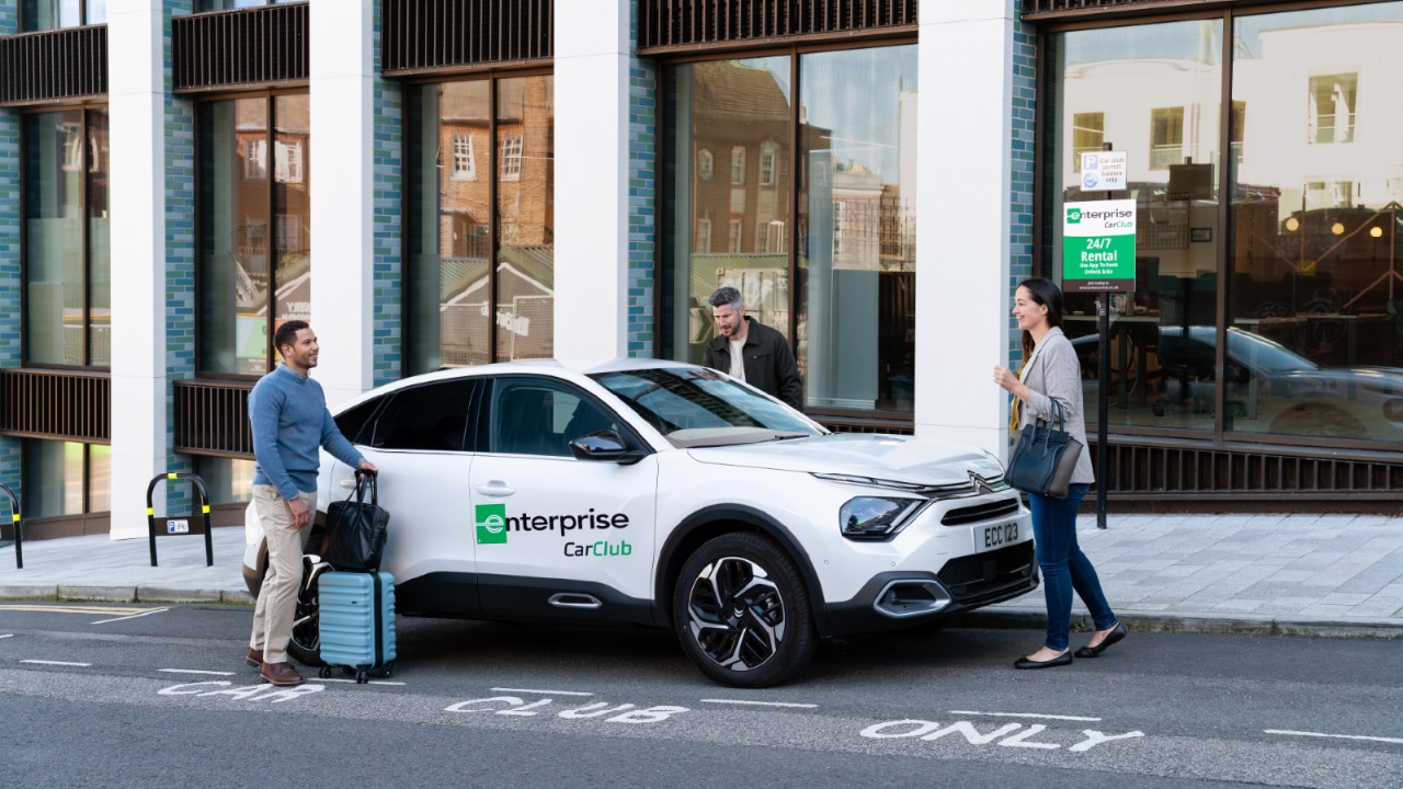 3 people getting into a Enteprise Car Club Vehicle.