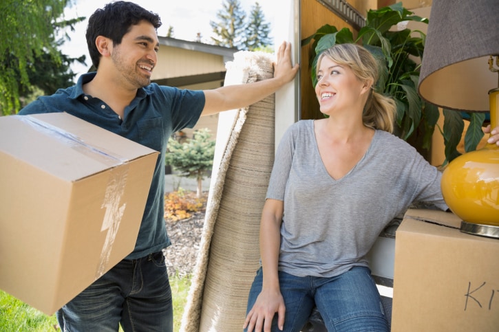 Couple unloading belongings from moving van